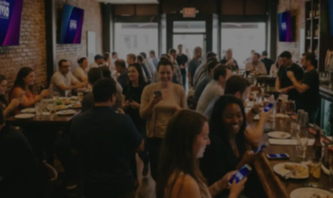 A busy bar with Buzztime trivia on every screen and players answering from their phones.